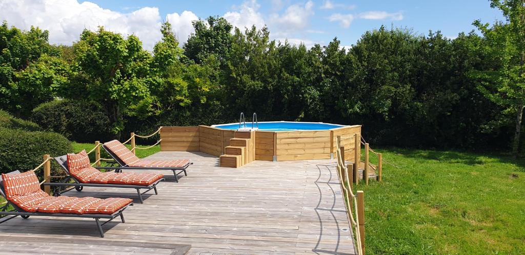 une terrasse en bois avec des chaises et une piscine dans l'établissement Maison au calme 6pers jardin, à Breuillet