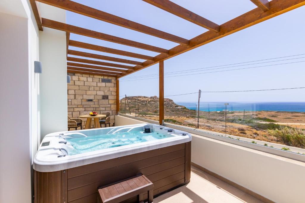 a bathroom with a tub and a large window at Elite Luxury Villas in Afiartis