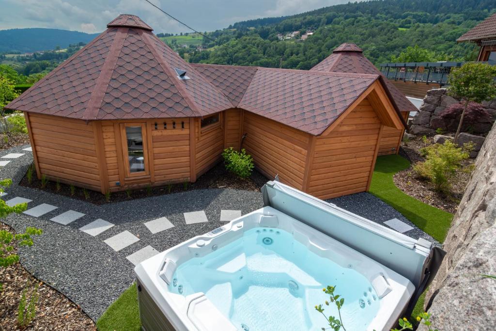 a building with a hot tub in front of it at Les Kotas du bonheur in Soultzeren