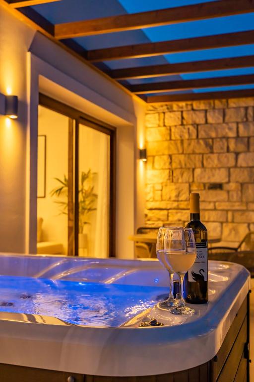 a tub with a bottle of wine and a wine glass at Elite Luxury Villas in Afiartis