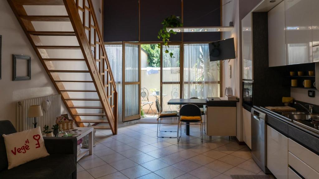 a kitchen with a staircase and a table with chairs at Ol Vegè casa in centro storico in Scanzorosciate