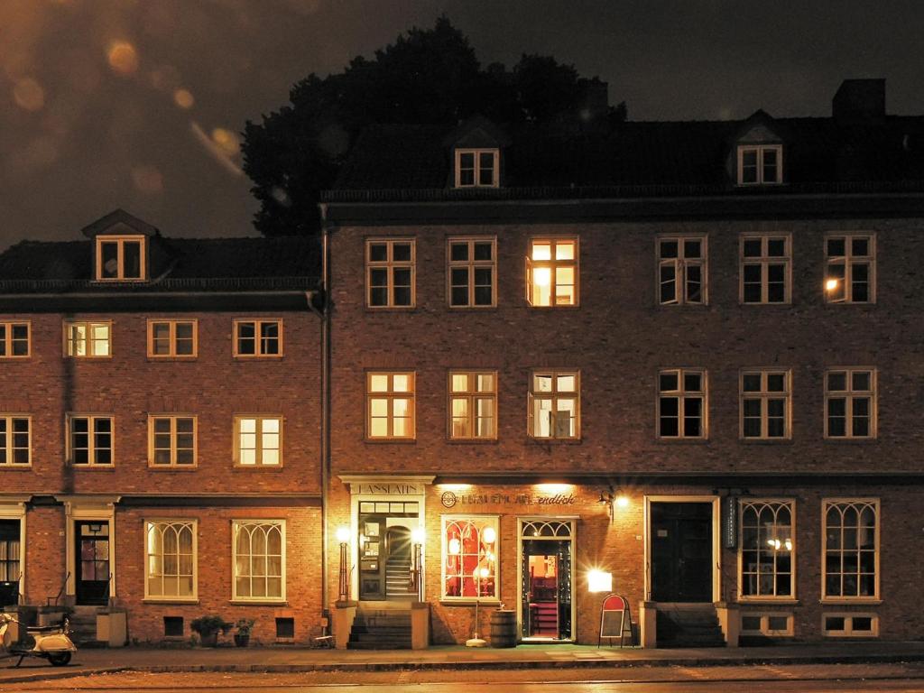 ein großes Backsteingebäude mit nachts eingeschaltetem Licht in der Unterkunft Frauenhotel Hanseatin - Women Only in Hamburg