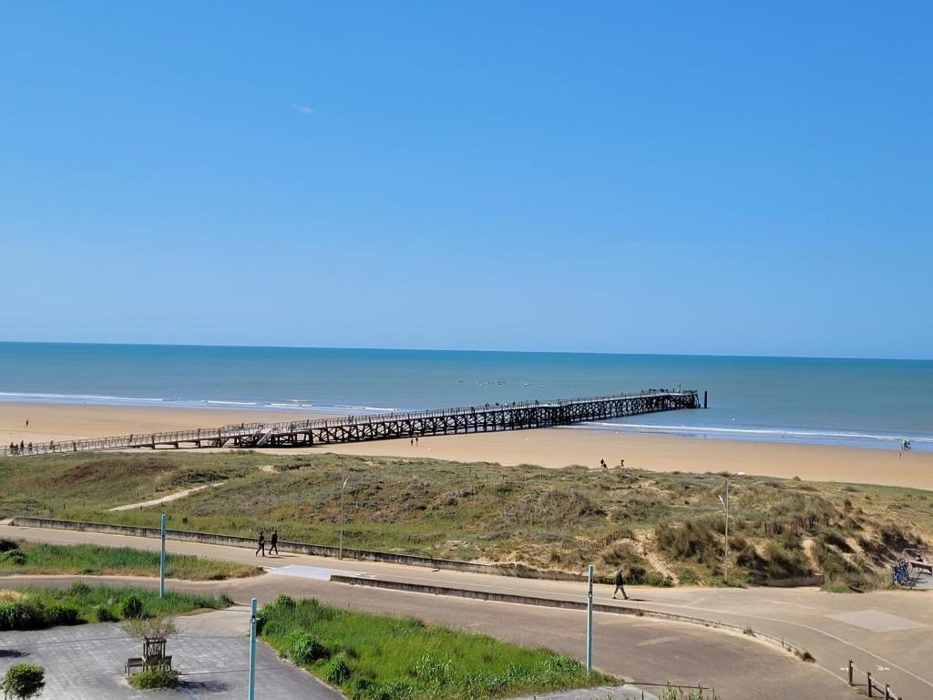 - une jetée sur la plage avec des personnes se promenant sur la plage dans l'établissement Les Mesanges Bleues, à Saint-Jean-de-Monts