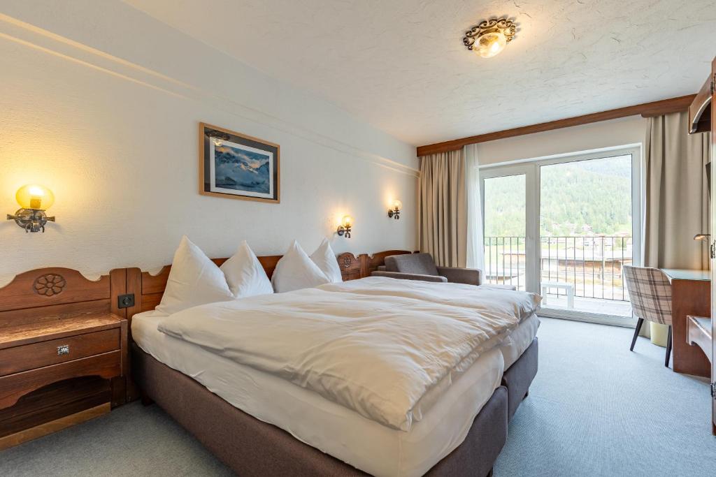 Postel nebo postele na pokoji v ubytování Hotel Dischma