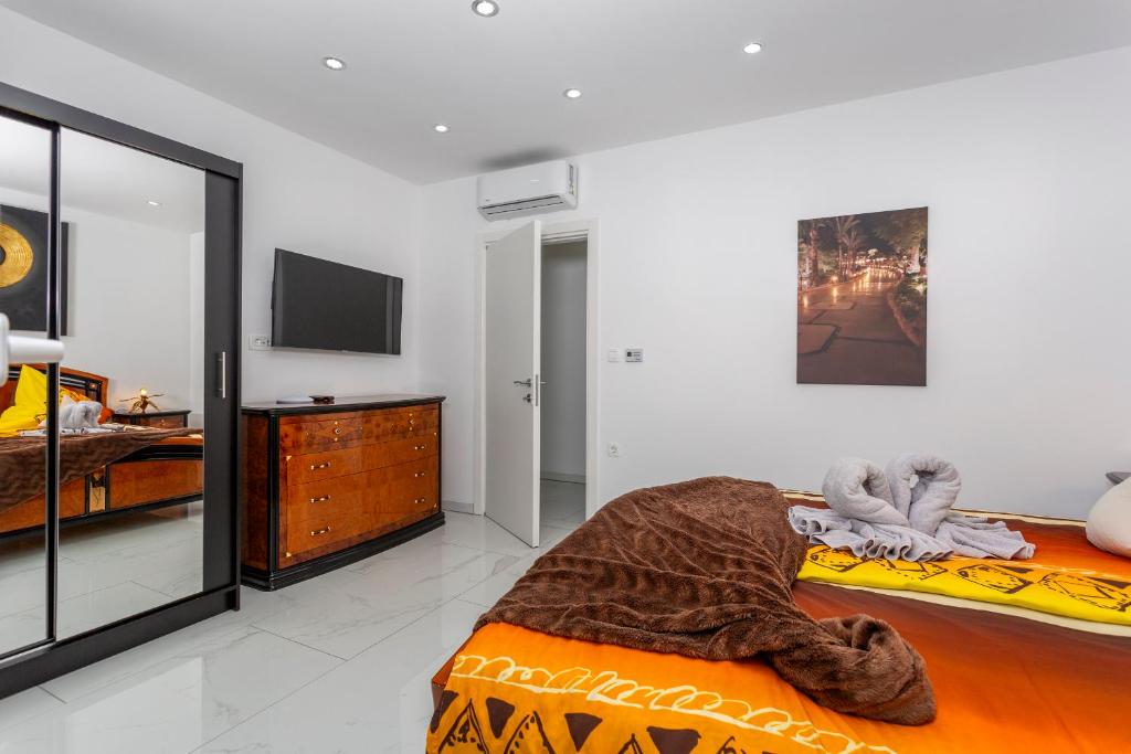 sypialnia z łóżkiem, komodą i telewizorem w obiekcie Villa White Pearl Diamond, Opatija mit Meerblick & Pool w mieście Opatija