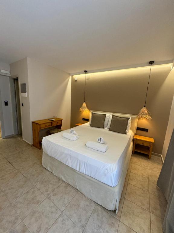 a bedroom with a large white bed with two towels on it at Marmari Paradise Resort Hotel in Marmari