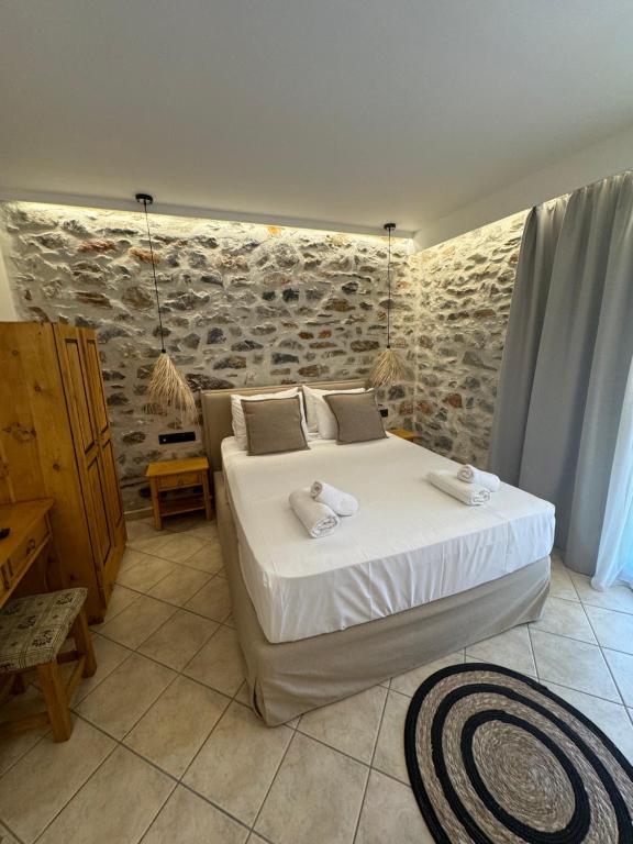 a bedroom with a bed and a stone wall at Marmari Paradise Resort Hotel in Marmari