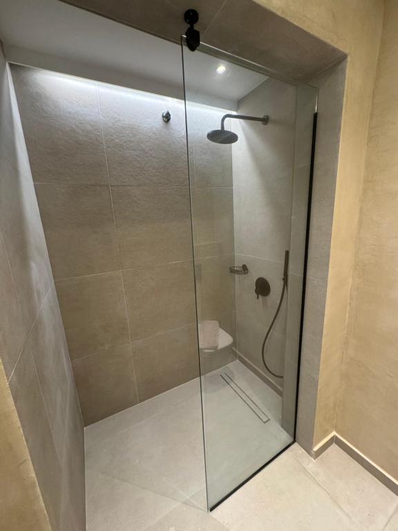 a shower with a glass door in a bathroom at Marmari Paradise Resort Hotel in Marmari