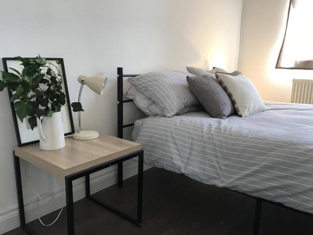 a bedroom with a bed and a table with a lamp at Amazing Cambridge house in Chesterton