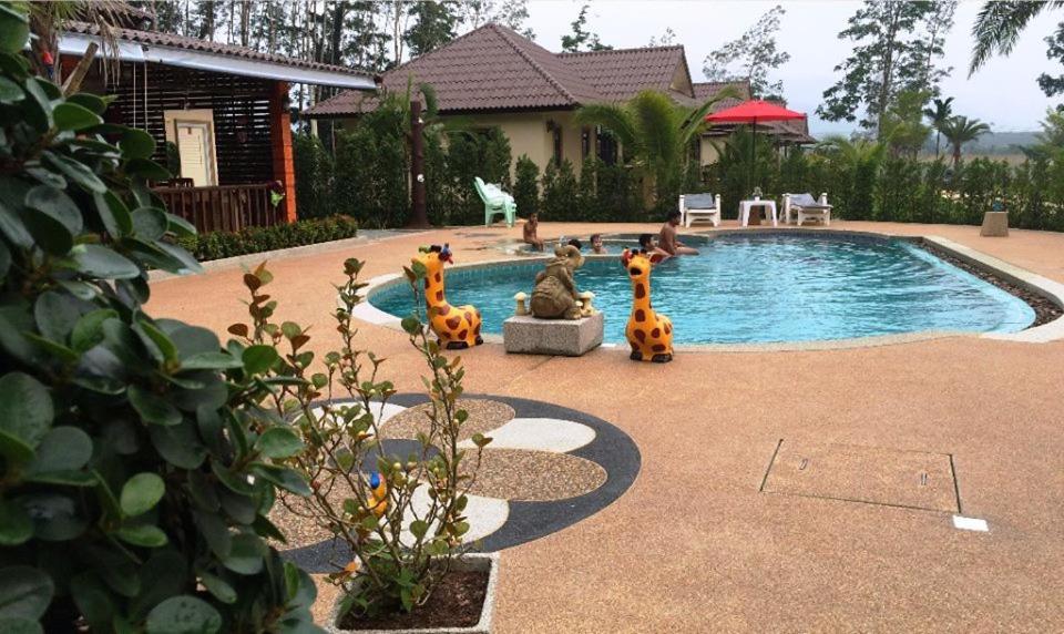 a swimming pool with toy animals in front of a house at Dachatorn Village in Khao Lak