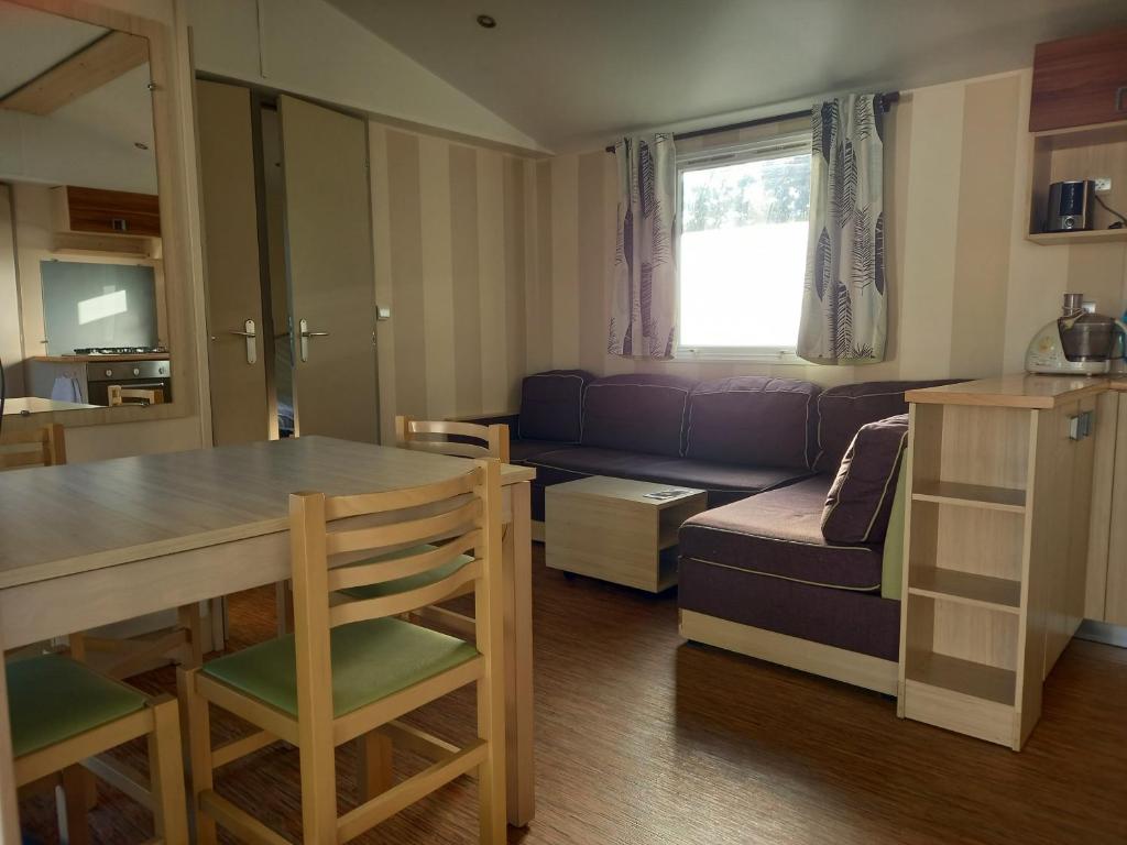 un salon avec une table et un canapé dans l'établissement mon bonheur, à Jullouville