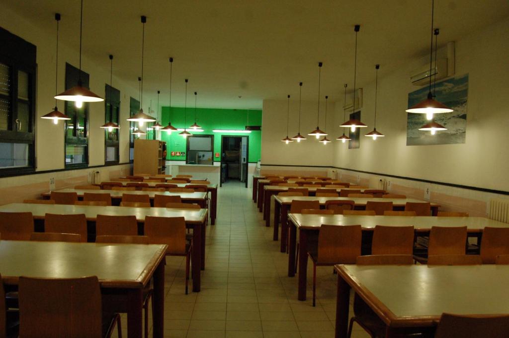 un comedor con mesas, sillas y luces en Alberg El Masnou Xanascat, en Teià