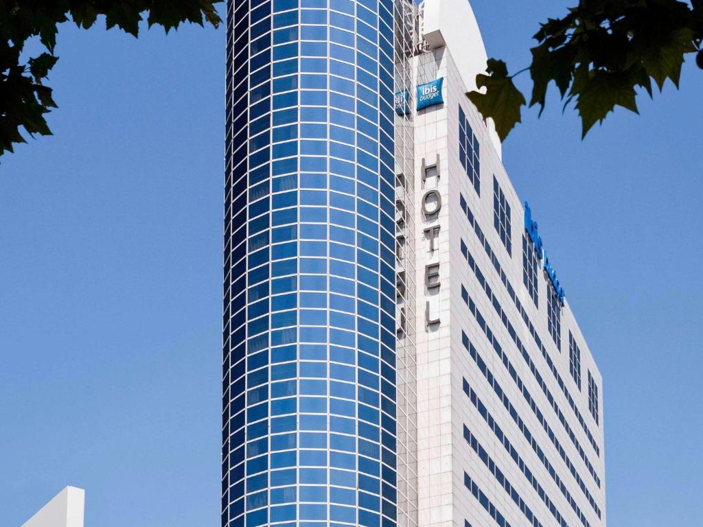 a tall glass building with a crane on top of it at ibis budget Paris Porte de Montreuil in Montreuil