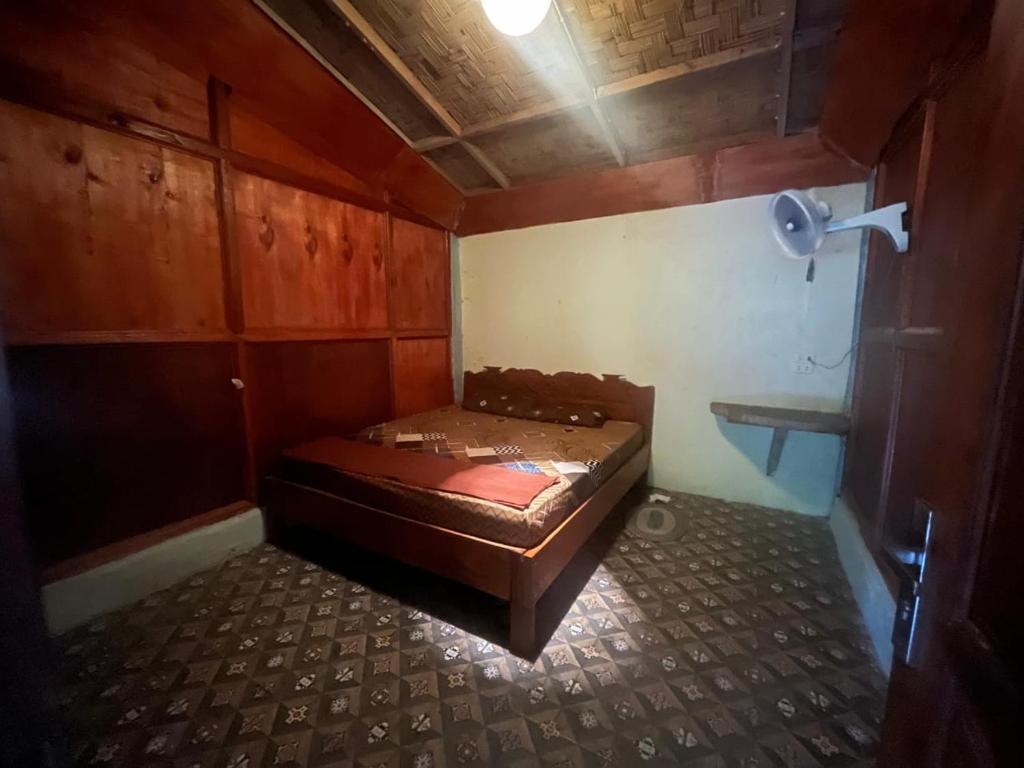 a small room with a bed in the corner at Pongo Guest House & only jungle trekking whit us in Bukit Lawang