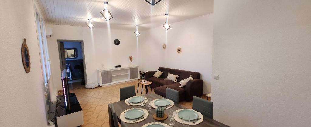 un salon avec une table et un canapé dans l'établissement Maison, à Vias