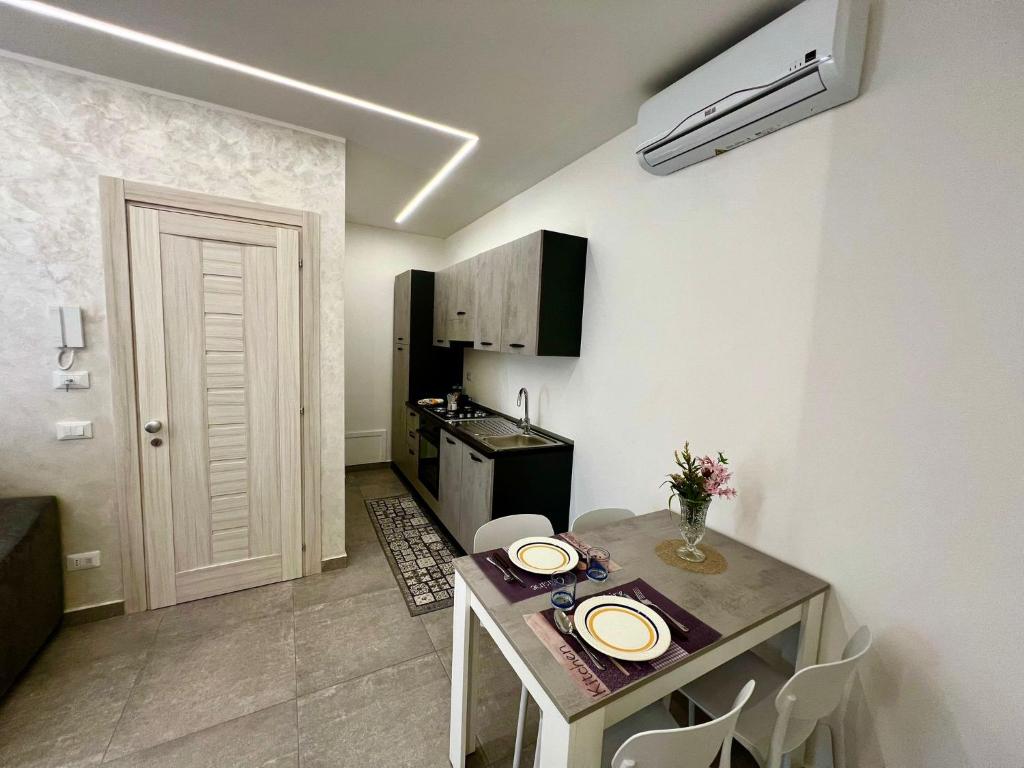 a small kitchen with a table with white plates on it at Flowers Apartments in Marineo