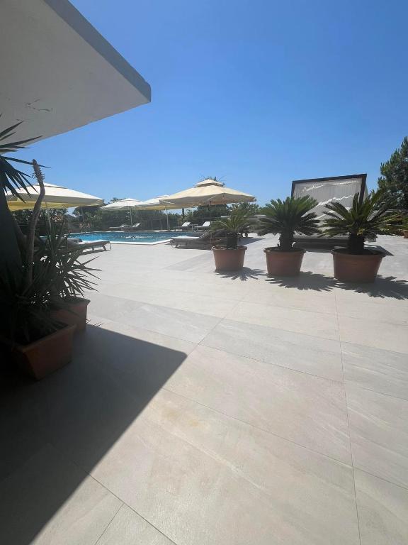 a patio with potted plants and umbrellas at Dela in Hvar