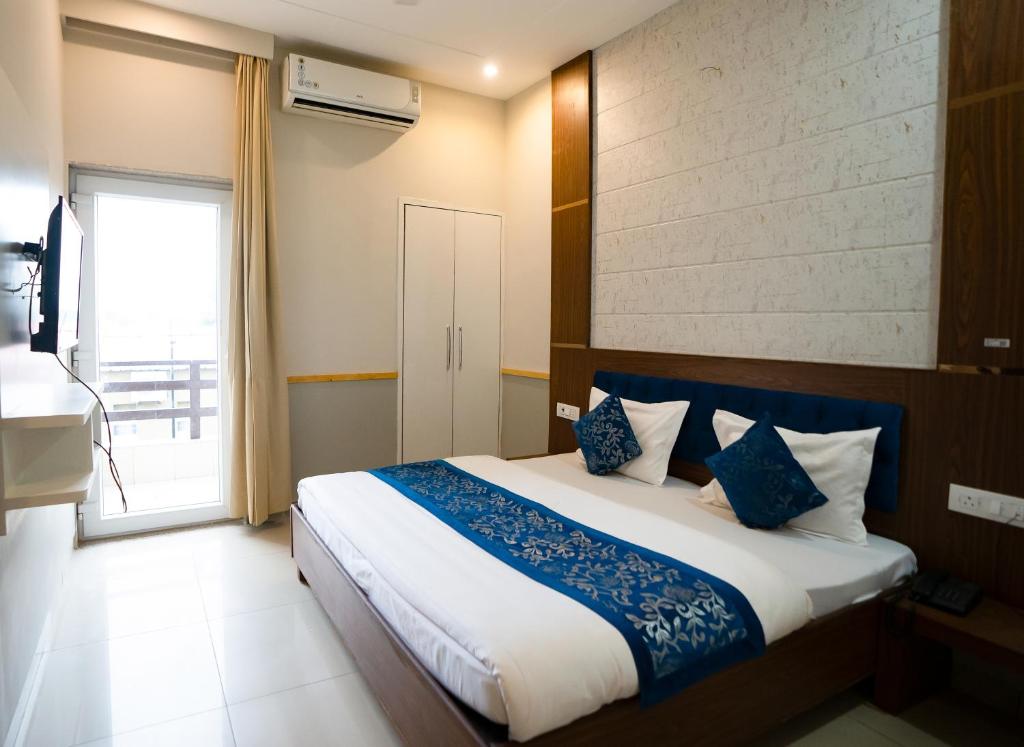 a bedroom with a large bed with blue and white pillows at Vrinda Anandam Resort in Vrindāvan