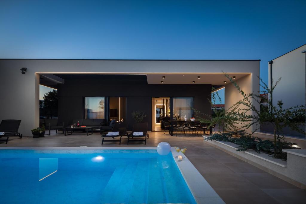 una casa con una piscina di fronte di Villa M a Vodice