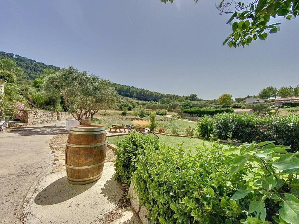 un tonneau assis au milieu d'un jardin dans l'établissement Havre de paix entre nature et mer, T2 refait à neuf, climatisé, idéal pour 4! - FR-1-770-18, à Saint-Cyr-sur-Mer