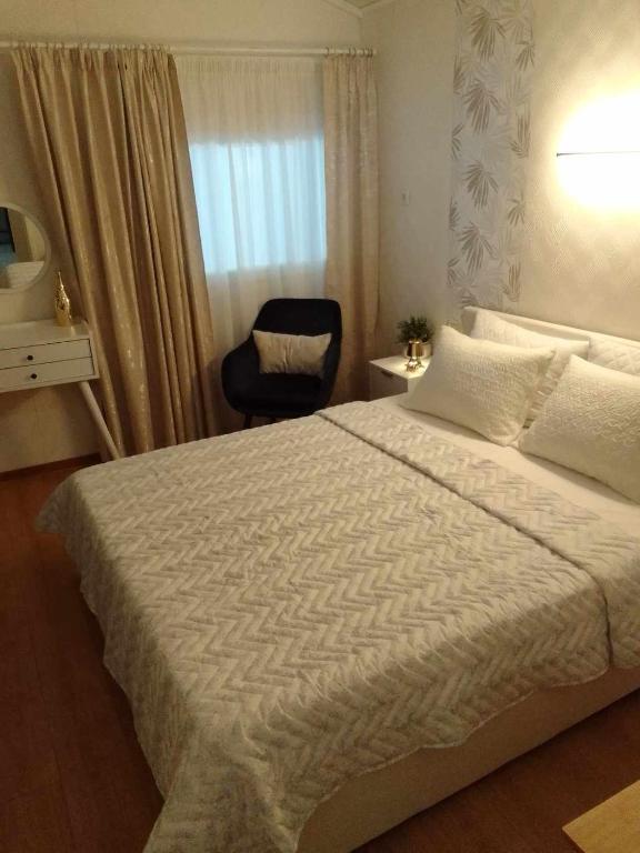 ein Schlafzimmer mit einem großen Bett und einem Stuhl in der Unterkunft Nikolas House in Asprovalta