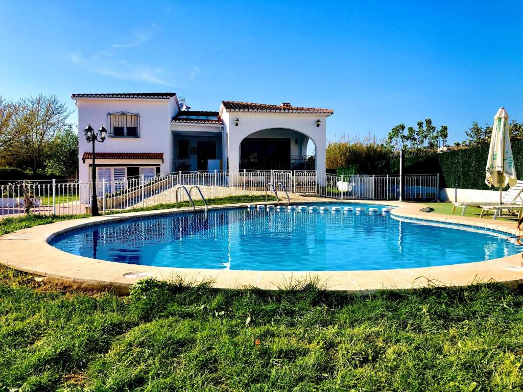 a swimming pool in front of a house at Kame House in Gandía