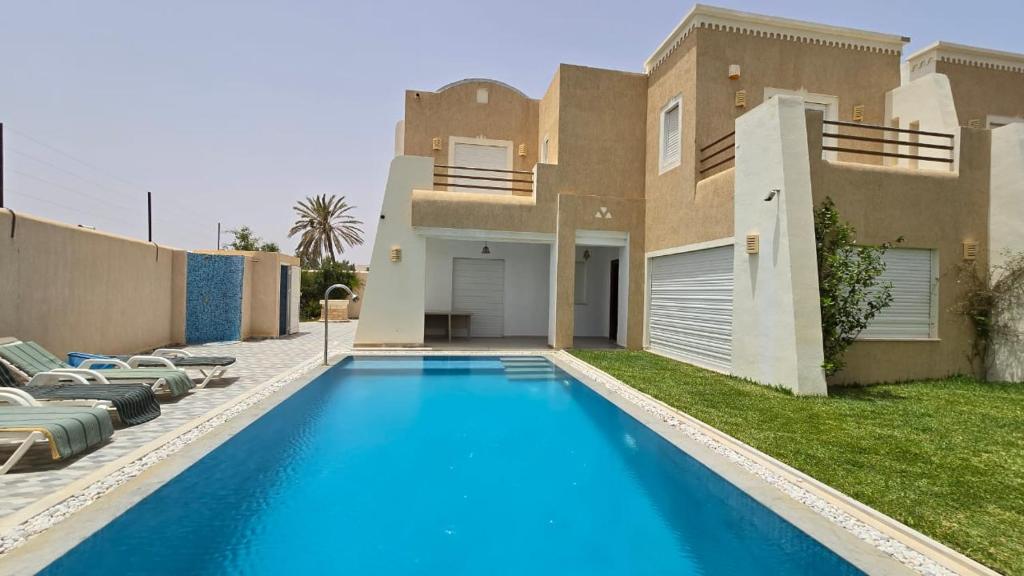 une villa avec piscine devant une maison dans l'établissement Villa Elaa, à Temlale