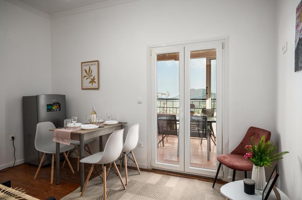 a dining room with a table and chairs and a balcony at Eveniki house in Pelekas