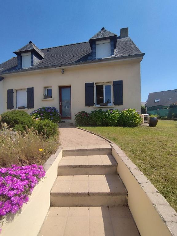 une maison avec une passerelle devant elle dans l'établissement Maison proche de la mer, à Saint-Méloir-des-Ondes