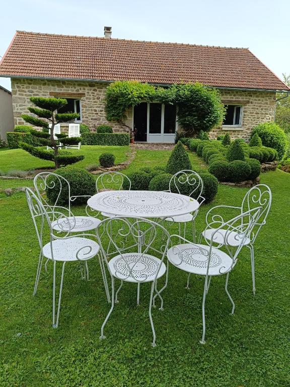 - une table et des chaises dans la cour d'une maison dans l'établissement Grand gîte deTranset, à Thauron