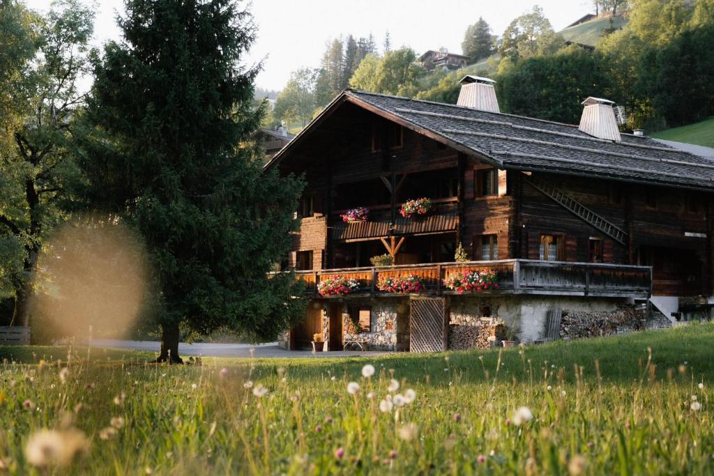 duży drewniany dom z kwiatami przed nim w obiekcie La Ferme du Var w mieście Clusaz
