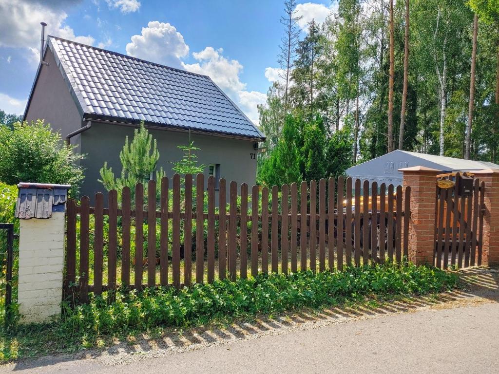 a wooden fence in front of a house at Domek w Borach in Nowe