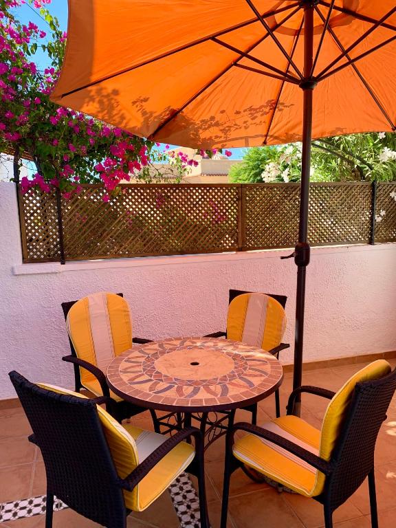 a table and chairs with an umbrella on a patio at LA BARRACA - A - Relax, Terraza cerca del mar in Mojácar