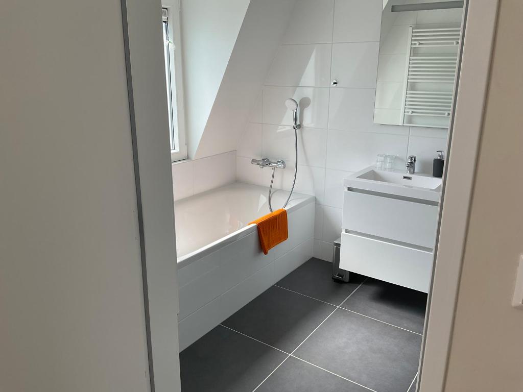 ein Badezimmer mit einer Badewanne und einem Waschbecken in der Unterkunft Aristoteles Apartments in Scheveningen