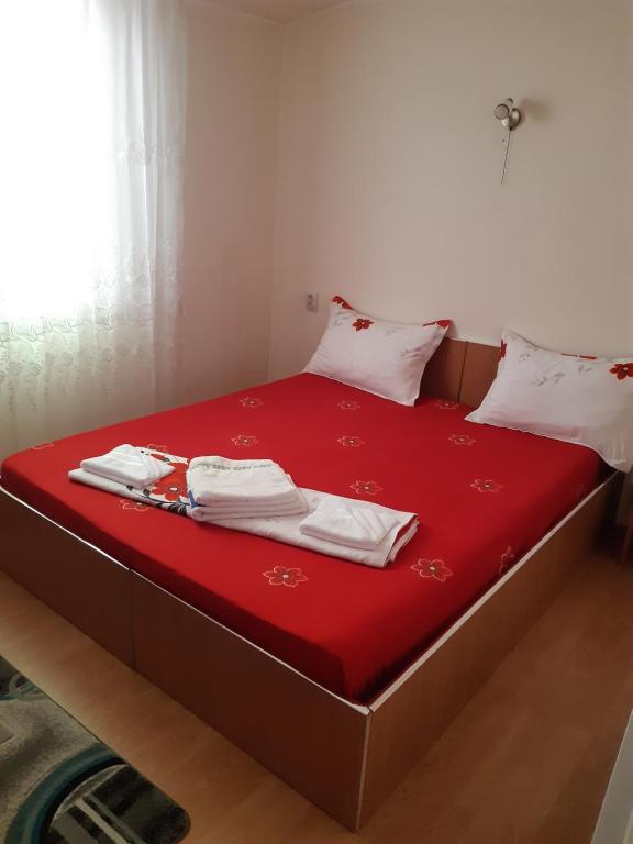 een bed met rode lakens en witte handdoeken bij CASA IZA in Băile Herculane