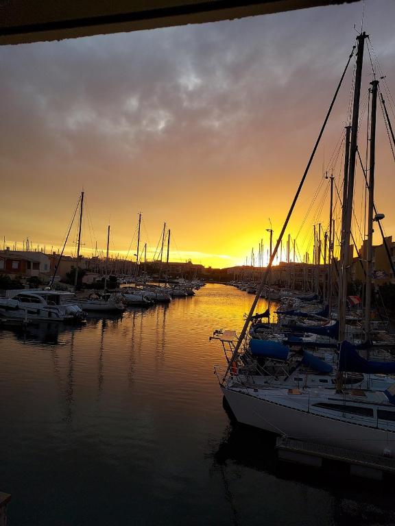 un groupe de bateaux amarrés dans une marina au coucher du soleil dans l'établissement appartement 2pièces, au Cap d'Agde