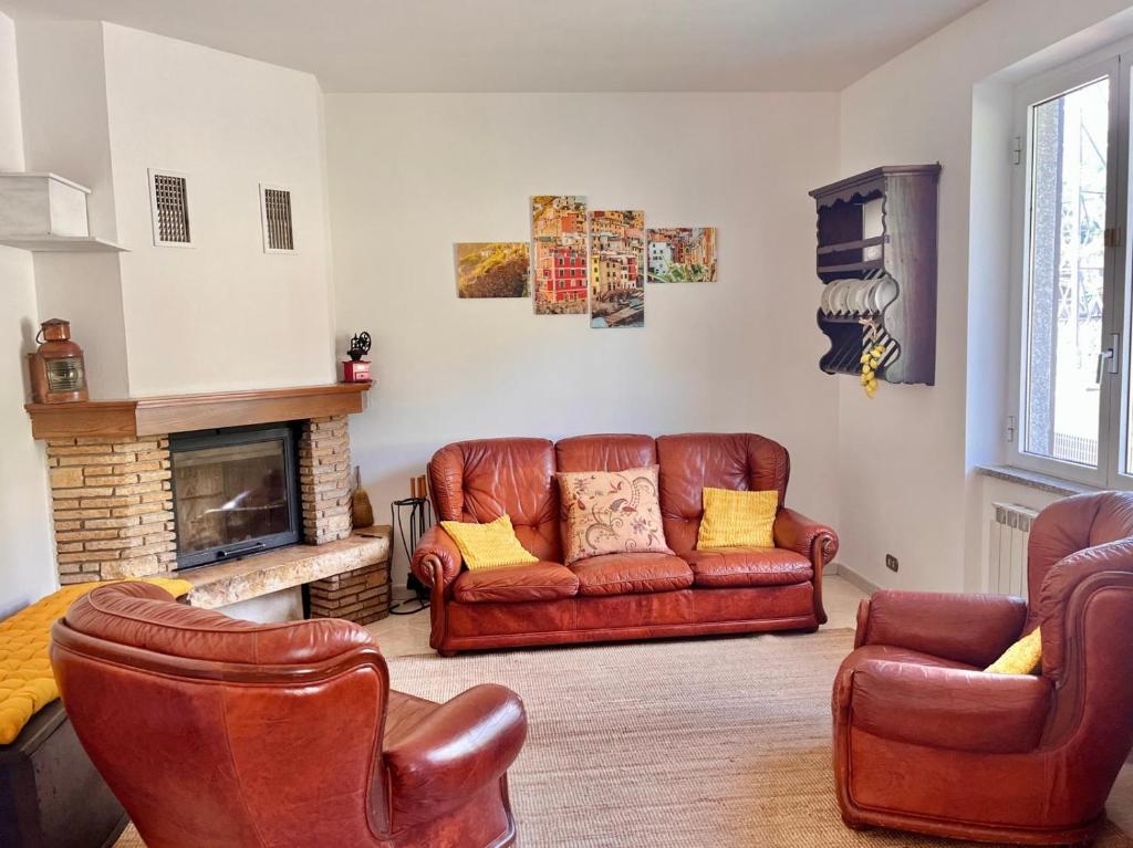 a living room with leather furniture and a fireplace at Villa Marcella - Near 5 Terre - Holiday Apartment in Serralta