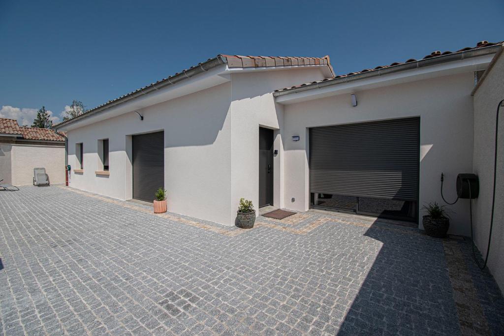 un bâtiment avec deux portes de garage et une allée. dans l'établissement Les Chanterelles, à Crêches-sur-Saône