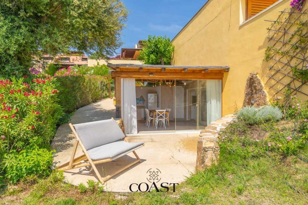 una silla sentada en un patio frente a una casa en Appartamento Smeraldo - Con vista mare, en Olbia