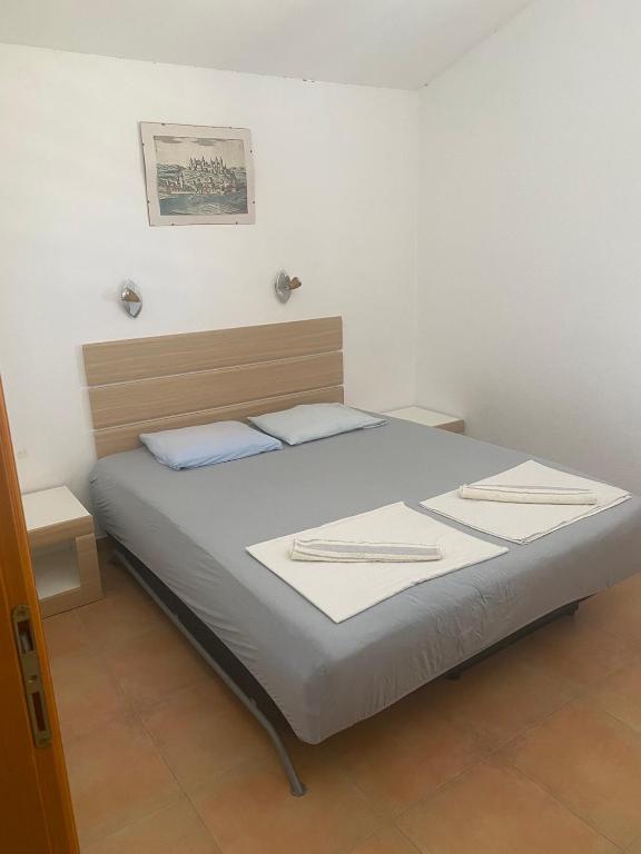 a bed in a bedroom with two towels on it at green olive 2 in Budva