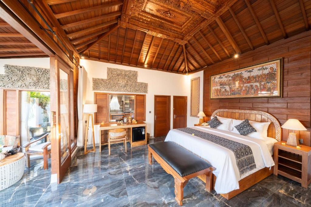 ein Schlafzimmer mit einem Bett und einem Schreibtisch in der Unterkunft Maddu Suites in Ubud