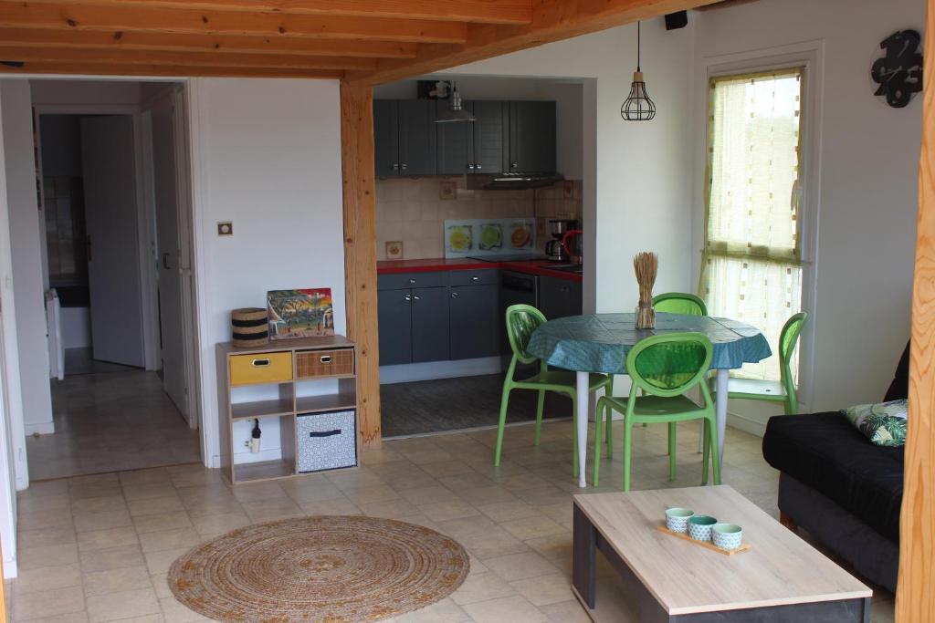 a living room with a table and a kitchen at Bord de mer in Saint-Jean-de-Monts