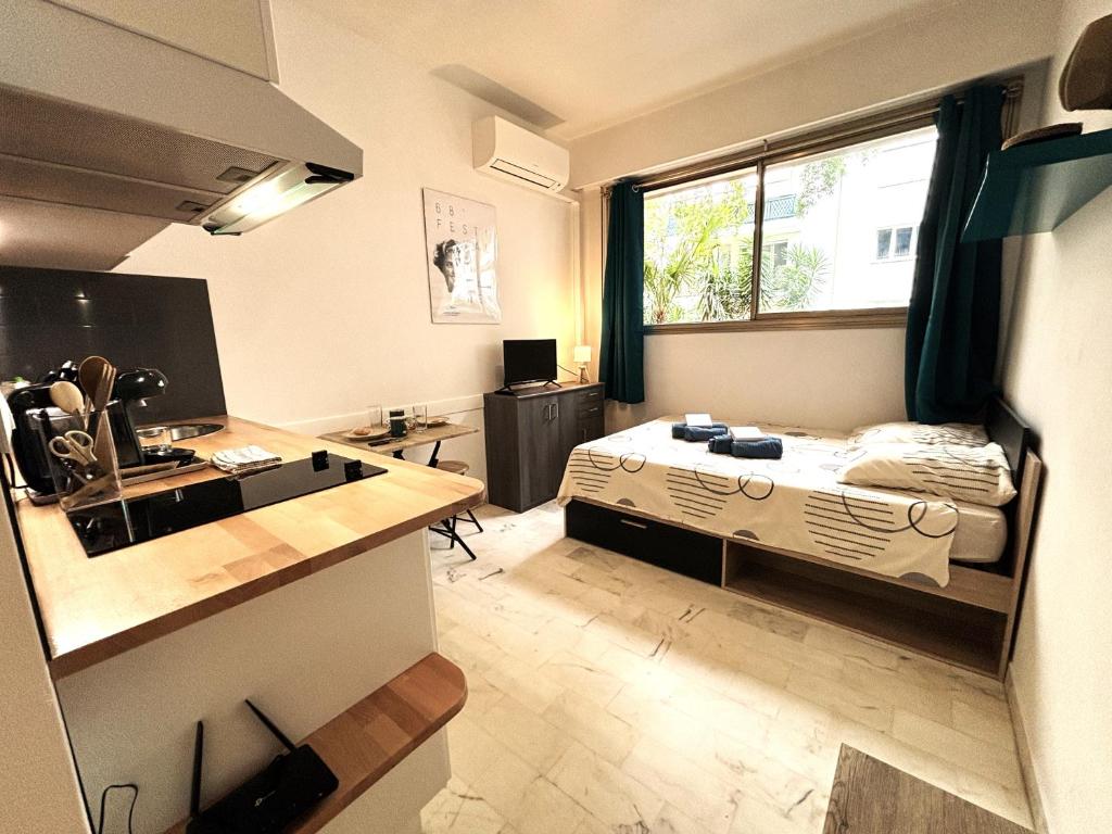 Cette petite chambre comprend un lit et un bureau. dans l'établissement Cannes center wifi AC 100 m from Croisette behind Martinez hotel, à Cannes