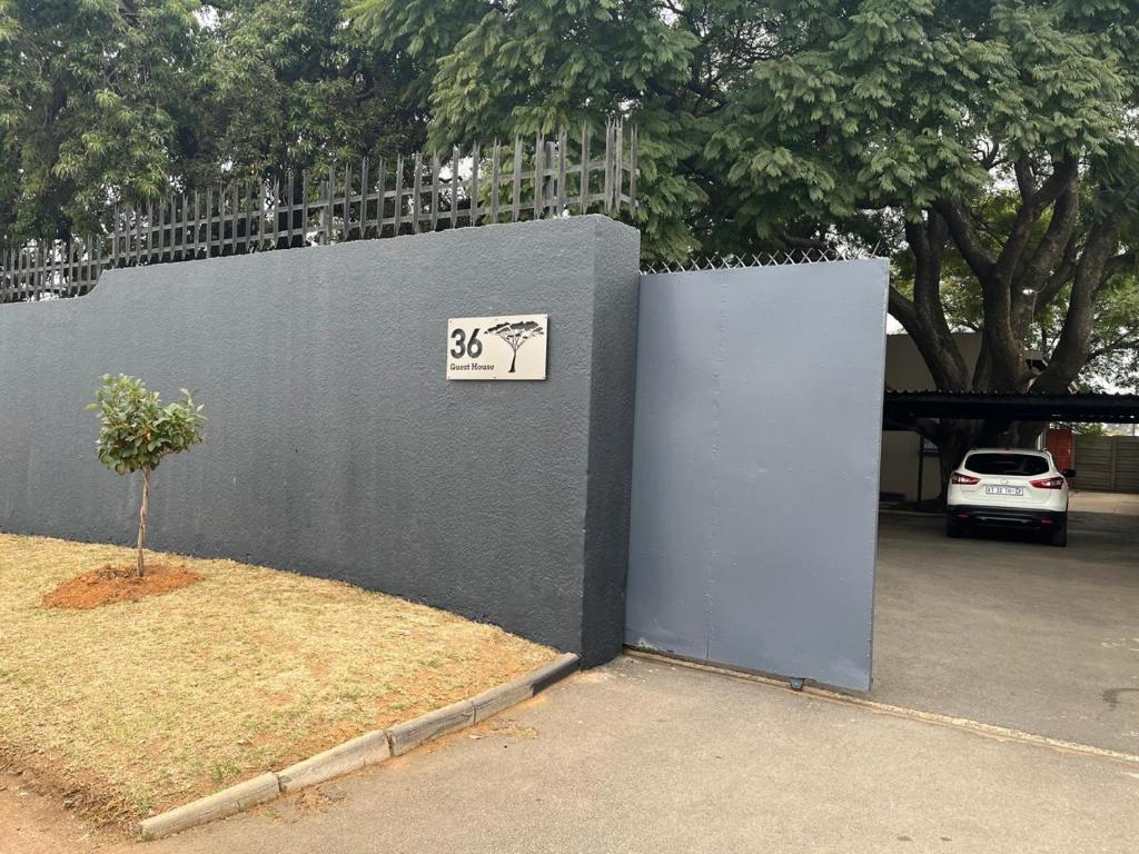 a wall with a sign on it next to a tree at Me Time in Johannesburg