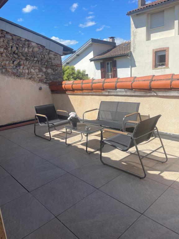 deux chaises et une table sur une terrasse dans l'établissement Les 3 clochers, à Pamiers