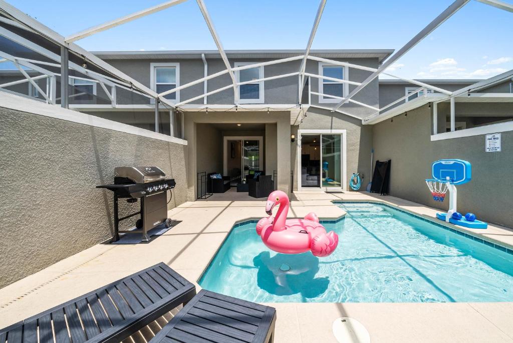 ein Schwimmbad mit zwei rosa Flamingos in einem Haus in der Unterkunft NEW Disney Golf Private Pool Gym Waterpark Resort in Kissimmee