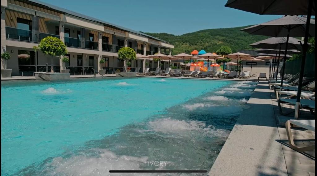 a swimming pool in a hotel with chairs and umbrellas at IVORY resort and spa in Vynohradiv