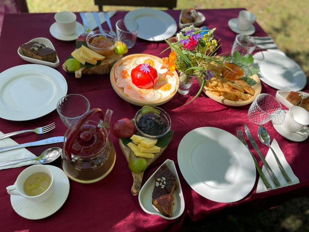 a purple table with plates of food on it at Guesthouse Prek Bjeshka in Theth