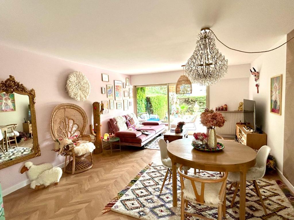 un salon avec une table et un lustre dans l'établissement Superbe 3P bohème, Juan les pins, jardin, 900m de la mer, à Antibes