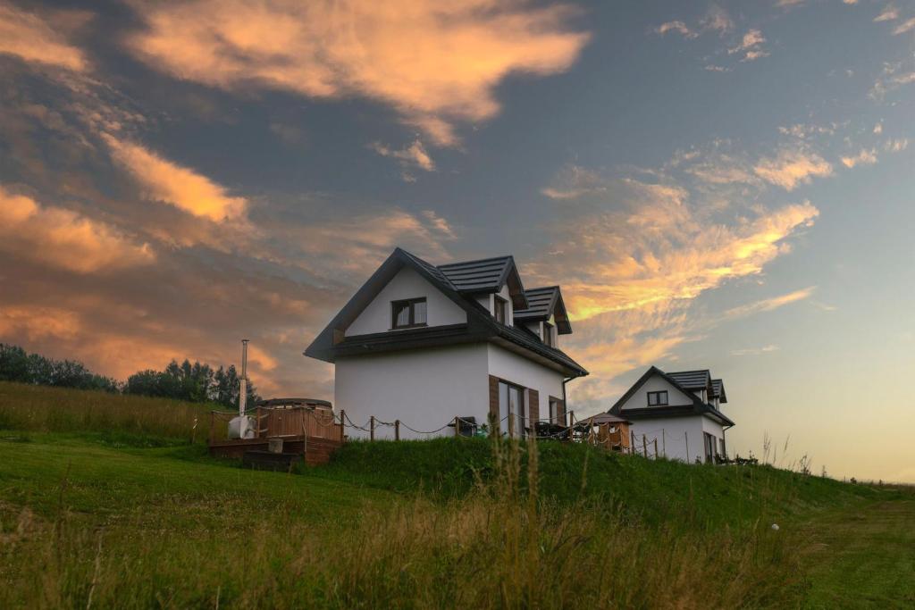 a house on top of a hill in a field at Dziewięćsił &Chaber _domki blisko lasu in Grywałd
